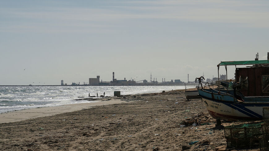 Children play on the beach with the Tunisian Chemical Group’s (CGT) phosphate complex visible in the background, in Gabes, Tunisia, October 16, 2025. REUTERS/Jihed Abidellaoui