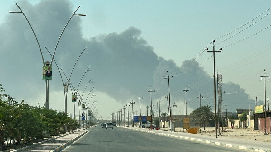 Smoke rises from a fire at an oil pipeline in Iraq's Zubair oilfield, as seen through a car window, near Basra, Iraq October 26, 2025. REUTERS/Mohammed Aty