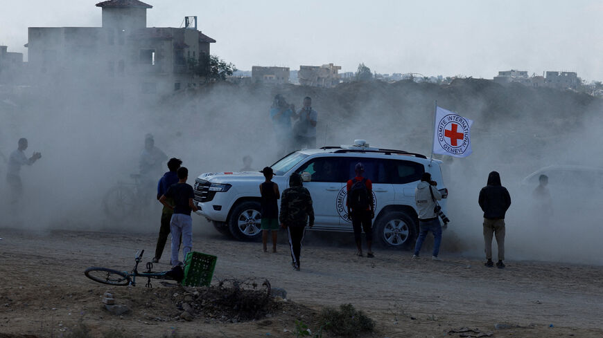 Palestinians gather around a Red Cross vehicle transporting hostages as part of a ceasefire and hostages-prisoners swap deal between Hamas and Israel, in the southern Gaza Strip, October 13. REUTERS/Mahmoud Issa