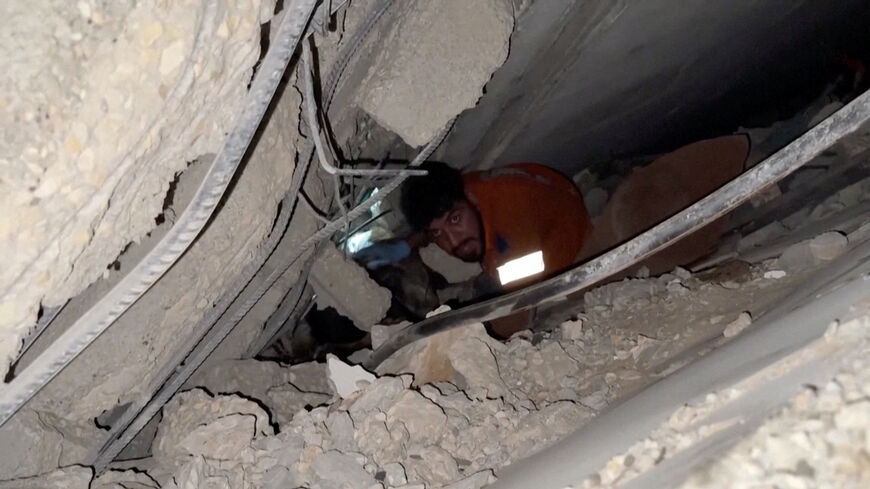 A rescuer works to free people trapped in rubble after an Israeli strike in Gaza City, October 28, 2025, in this still image taken from video.   Obtained by Reuters/Handout via REUTERS    THIS IMAGE HAS BEEN SUPPLIED BY A THIRD PARTY. NO RESALES. NO ARCHIVES