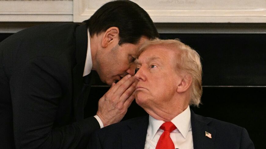 US Secretary of State Marco Rubio whispers in the ear of President Donald Trump 