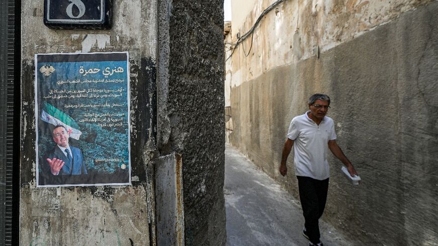 An election poster of Henry Hamra, a Jewish Syrian-American parliamentary candidate, is displayed on the entrance of the closed Jewish Maimonides School of Damascus