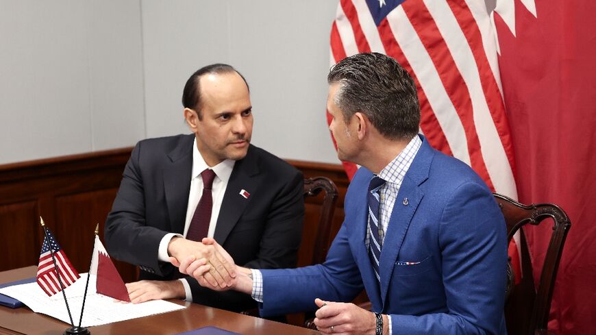 US Defense Secretary Pete Hegseth (R) and Qatari Defense Minister Sheikh Saoud bin Abdulrahman Al Thani shake hands after signing a deal to establish a Qatari Emiri Air Force training facility at the Mountain Home Air Force Base in Idaho
