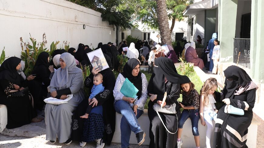 Syrian nationals wait at a service office in Tripoli after the Syrian foreign ministry announced it would grant free return tickets to its citizens wishing to leave Libya