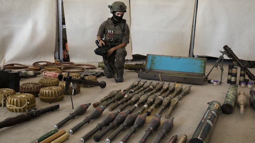 An Israeli soldier displays military equipment and ammunition that Hamas and Palestinan militants used at the time of the attack on the Israeli south border with the Gaza Strip on Oct. 20, 2023, in Kiryat Malakhi, Israel.