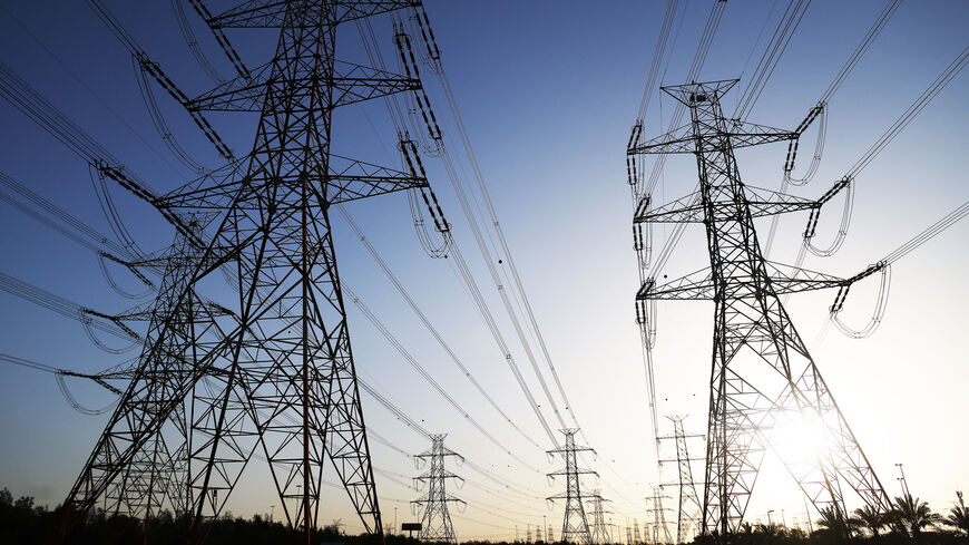 The sun sets behind overhead power lines as the Kuwaiti Ministry of Electricity requested citizens to ration their electricity usage at peak times due to outages caused by the increased pressure on power stations amid soaring temperatures and heightened energy demand, Kuwait City, Kuwait, June 19, 2024.