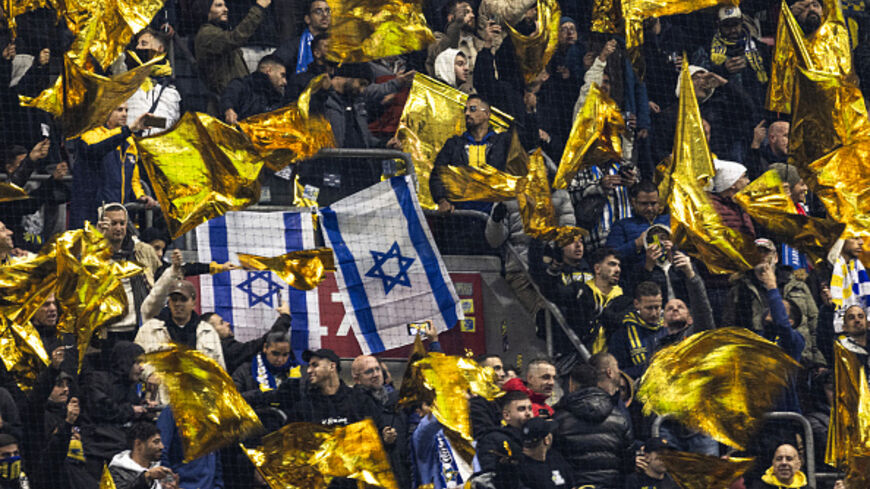OPSHOT - Maccabi supporters wave yellow flags next to Israeli flags during the UEFA Europa League, League phase - Matchday 4, football match between Ajax Amsterdam and Maccabi Tel Aviv at the Johan-Cruijff stadium, in Amsterdam on November 7, 2024. (Photo by Robin van Lonkhuijsen / ANP / AFP) / Netherlands OUT (Photo by ROBIN VAN LONKHUIJSEN/ANP/AFP via Getty Images)