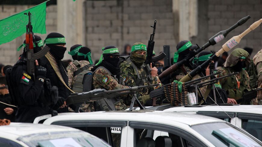 Palestinian Hamas fighters carry their guns in Nuseirat in the central Gaza Strip as preparations take place for the release of three Israeli hostages, as part of the seventh hostage-prisoner swap on Feb. 22, 2025.