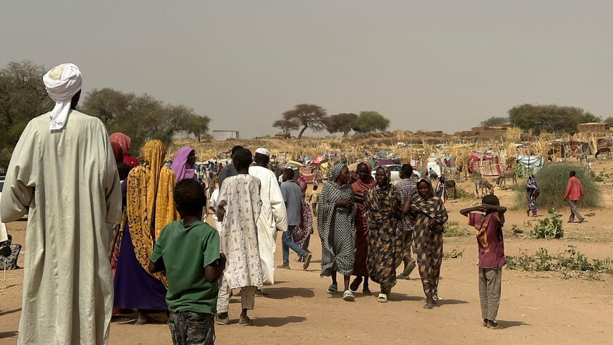 People who fled the Zamzam camp for the internally displaced after it fell under RSF control walk in a makeshift encampment in an open field near the town of Tawila in war-torn Sudan's western Darfur region on April 13, 2025. 