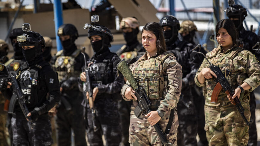 Members of the Syrian Kurdish Asayish security forces stand guard at the Kurdish-run al-Hol camp, which holds relatives of suspected Islamic State (IS) group fighters in the northeastern Hasakeh governorate, on April 18, 2025, as the Syrian Democratic Forces mount a security campaign against IS "sleeper cells" in the camp. 