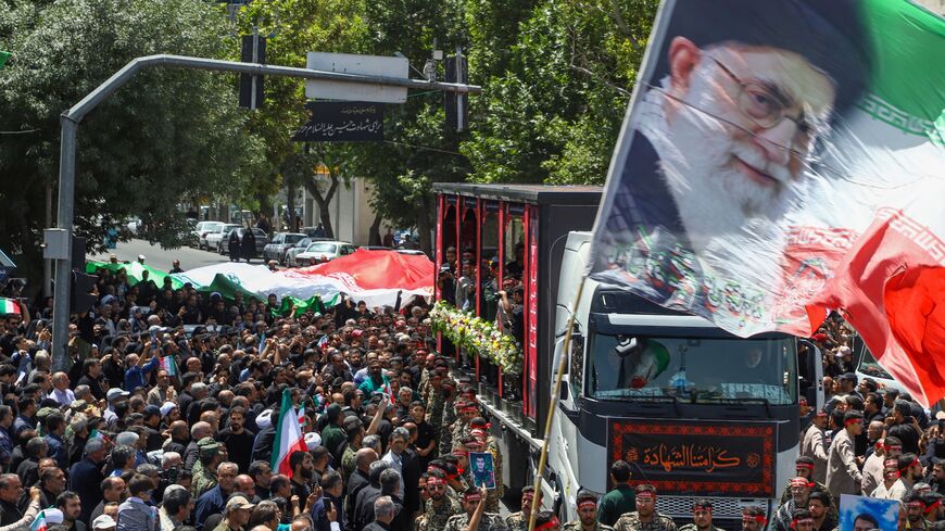 In this picture obtained from Iran's ISNA news agency, a flag with the portrait of Iran's supreme leader, Ayatollah Ali Khamenei, is waved during the funeral procession of 15 people killed in Israeli strikes during the 12-day war between Israel and Iran, in the city of Mashhad on June 27, 2025. 
