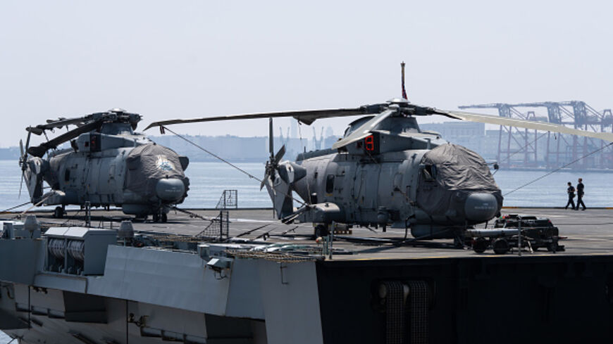 TOKYO, JAPAN - AUGUST 31: Members of the British Royal Navy walk near helicopters parked aboard HMS Prince of Wales, the navy's flagship aircraft carrier, during a public ship tour at the Tokyo International Cruise Terminal on August 31, 2025, in Tokyo, Japan. The aircraft carrier was opened to the public in connection with the UK Carrier Strike Group's (CSG) port call in Tokyo. The group has been in Japan since August 12 for joint training exercises. (Photo by Tomohiro Ohsumi/Getty Images)