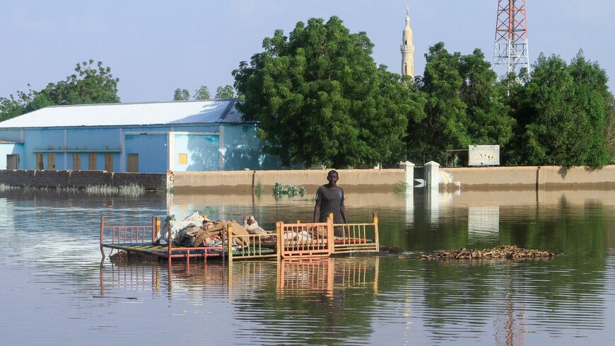 A resident stands by belongings to salvage in a pool of water due to the flooding of the Nile river in the Sudanese village of Wad Ramli north of Khartoum on Oct. 1, 2025.