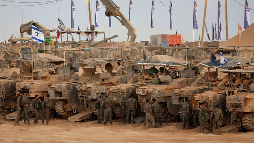 Israeli army soldiers gather near infantry-fighting vehicles (IFVs) at a position along the Israel-Gaza border fence on October 10, 2025. Gaza's civil defence agency said October 10 that Israeli forces have begun pulling back from parts of the territory, particularly in Gaza City and Khan Yunis. Israeli prime minister's office said that the government had "approved the framework" of a hostage release deal with Hamas, as both sides edged closer to ending more than two years of hostilities in Gaza. (Photo by 