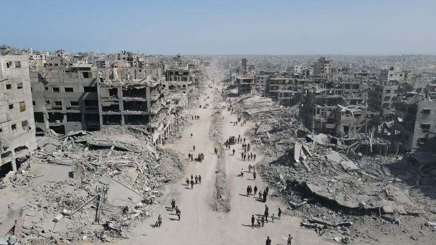In this aerial view, people walk amid the destruction in Gaza City in the northern Gaza Strip, on Oct. 11, 2025, a day after a ceasefire took effect. 