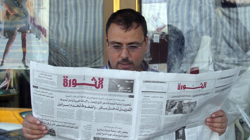 A Syrian reads the state-run daily newspaper al-Thawra outside his shop in downtown Damascus on Sept. 3, 2004. 