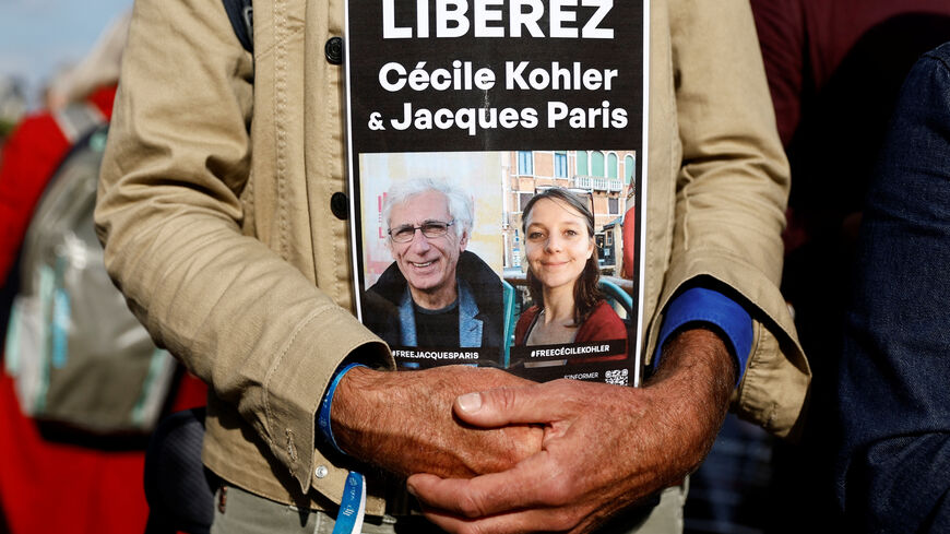 A man holds a placard with the portraits of Cecile Kohler and Jacques Paris, two French citizens held in Iran, during a support rally to mark their three-year detention and to demand their release, at Place de la Nation in Paris, France, May 7, 2025. The slogan reads "Freedom for Cecile Kohler and Jacques Paris". REUTERS/Abdul Saboor
