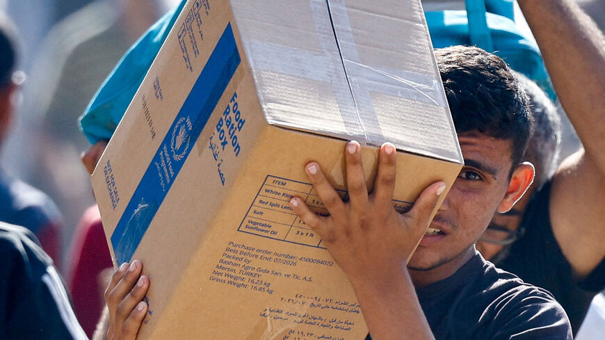 A Palestinian carries aid supplies that entered Gaza, amid a ceasefire between Israel and Hamas in Gaza, in Zawaida in the central Gaza Strip. REUTERS/Mahmoud Issa
