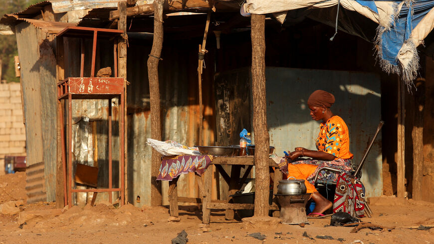A woman prepares food on the road side, amid ongoing fuel shortages caused by a blockade imposed by al Qaeda-linked insurgents in early September, in Bamako, Mali, October 31, 2025. REUTERS/Stringer