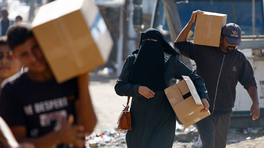 Palestinians carry aid supplies that entered Gaza, amid a ceasefire between Israel and Hamas in Gaza, in Zawaida, in the central Gaza Strip, October 21, 2025. REUTERS/Mahmoud Issa