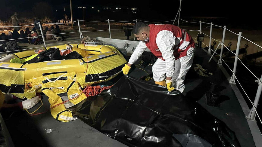 A Red Crescent worker moves a body bag, after two boats carrying migrants capsized off the Libyan coastal city of Al Khums causing multiple casualties, in a location given as Khums, Libya, November 15, 2025. LIBYAN RED CRESCENT SOCIETY IN KHUMS/Handout via REUTERS