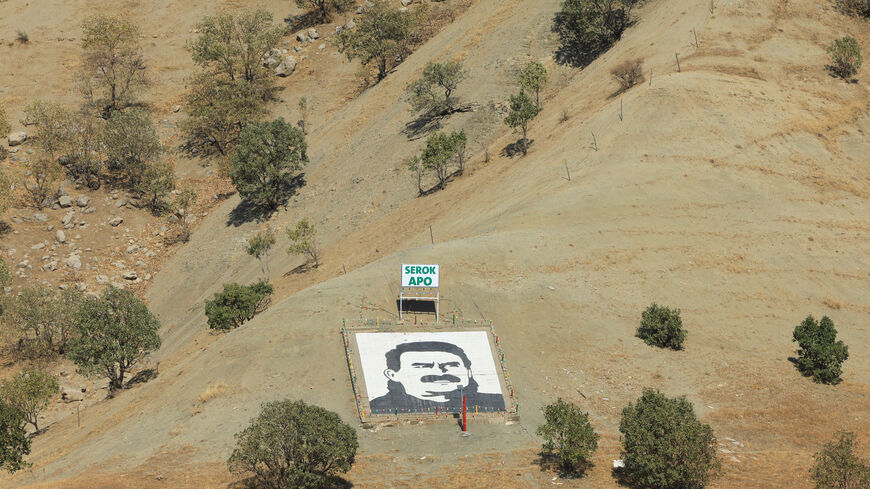 A portrait of jailed Kurdistan Workers Party (PKK) leader Abdullah Ocalan and a sign with the words "Serok Apo," are displayed on a hillside in the Qandil mountains, Iraq, October 26, 2025. REUTERS/Thaier Al-Sudani