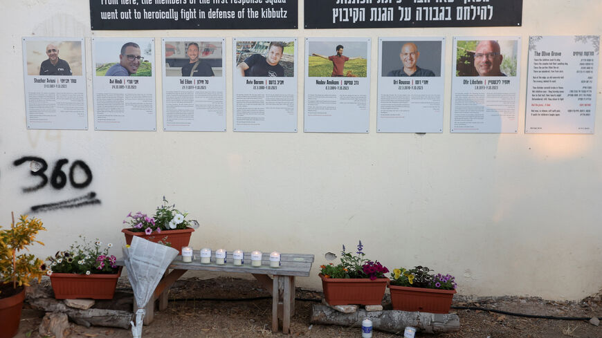 Flower tributes and candles are places in front of posters on a wall during a memorial to commemorate the two-year anniversary of the deadly October 7, 2023 attack on Israel by Hamas from Gaza, in Kibbutz Kfar Aza, southern Israel, October 7, 2025. REUTERS/Ronen Zvulun