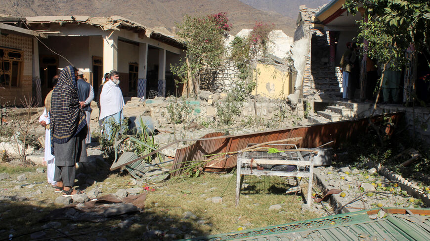People stand in front of damaged houses that the Afghan Taliban government said were damaged after Pakistan carried out raids, in Asadabad, Kunar province, Afghanistan, November 25, 2025. REUTERS/Stringer