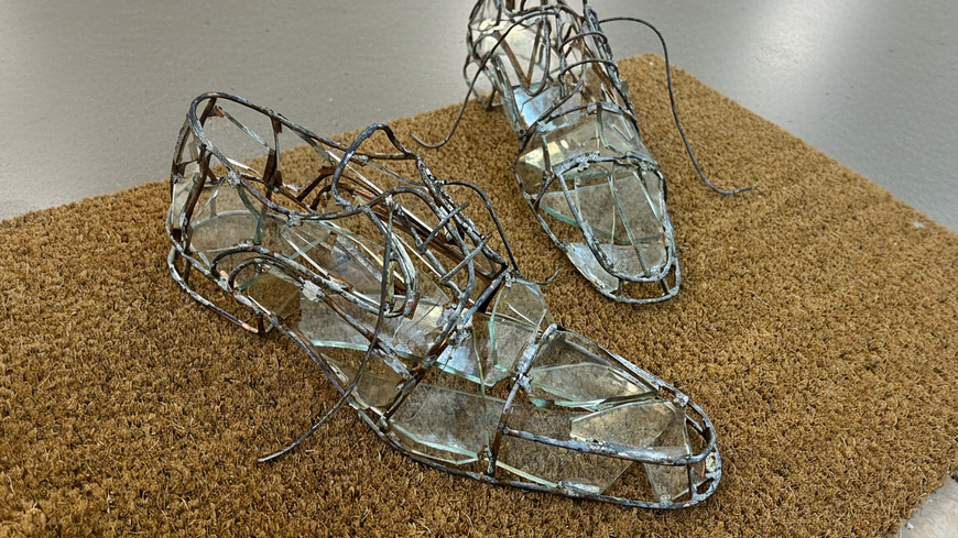 In “As If Present,” Aysegul Karababa sets empty glass shoes at the threshold, echoing her childhood ritual of staging her father’s return to make the house feel safe (BASE)