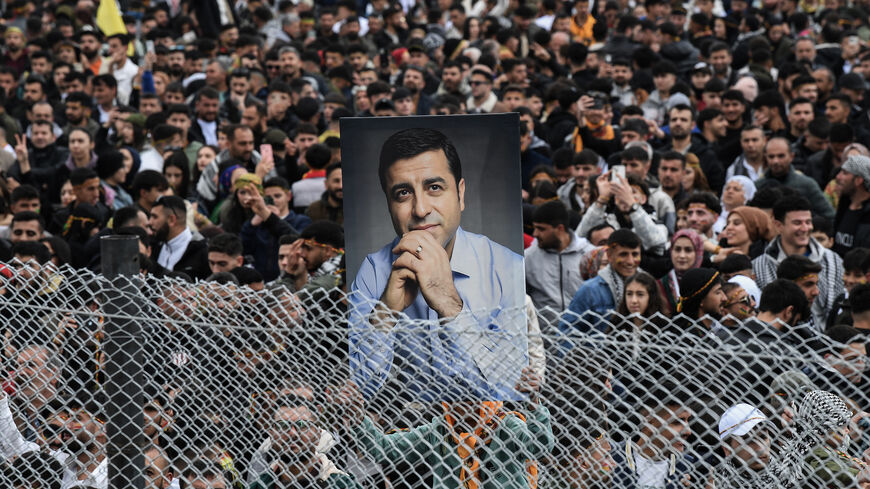A man holds a portrait of Selahattin Demirtas during a gathering of Turkish Kurds for Nowruz celebrations marking the New Year of the Persian calendar and the first day of spring, Diyarbakir, southeastern Turkey, March 21, 2025.