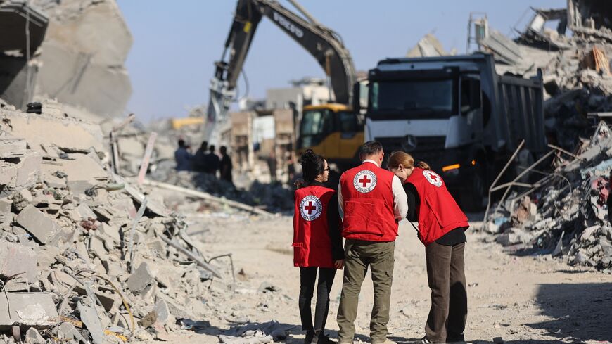 Members of the Red Cross stand amid the rubble of destroyed buildings as heavy machinery operates in the al-Tuffah neighborhood of Gaza City on Oct. 27, 2025. 