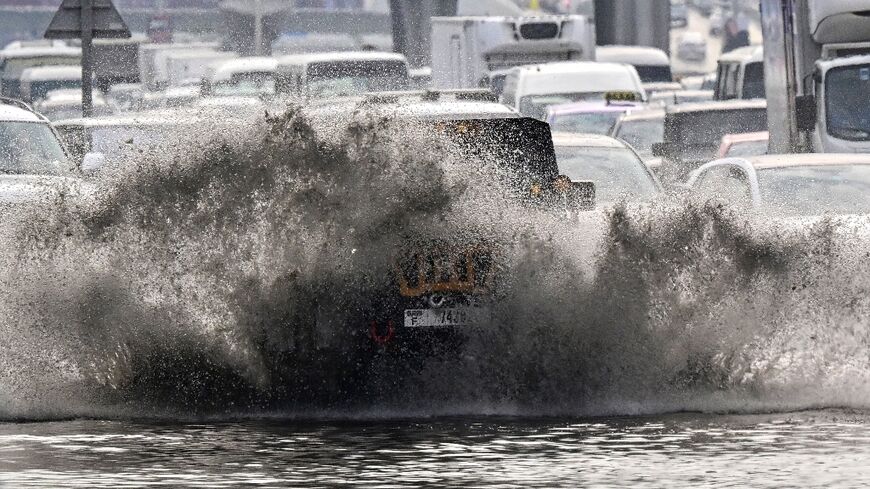 Vehicles negotiate a flooded road in Dubai on December 18, 2025