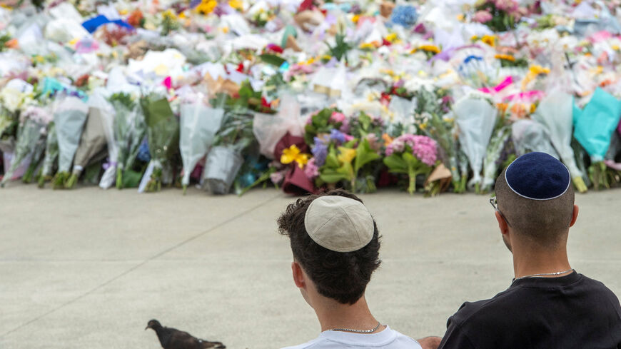 Members of the Jewish community sit near the floral tribute at Bondi Beach to honour the victims of a mass shooting targeting a Hanukkah celebration on Sunday at Bondi Beach, in Sydney, Australia, December 16, 2025. REUTERS/Jeremy Piper