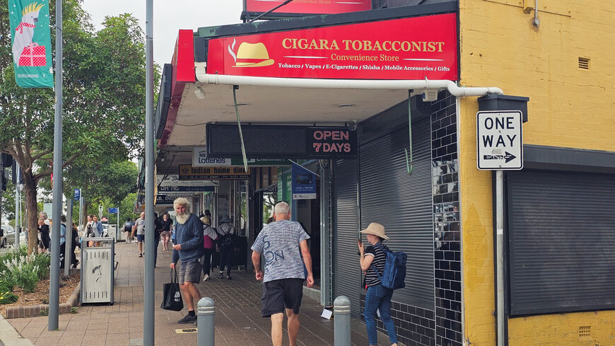 People walk past tobacco shop owned by Ahmed al Ahmed, the bystander who is hailed as the "Bondi hero" after he charged at one of the gunmen and seized his rifle during the deadly shooting at Bondi Beach, in Sydney, Australia, December 16, 2025. Reuters/Cordelia Hsu