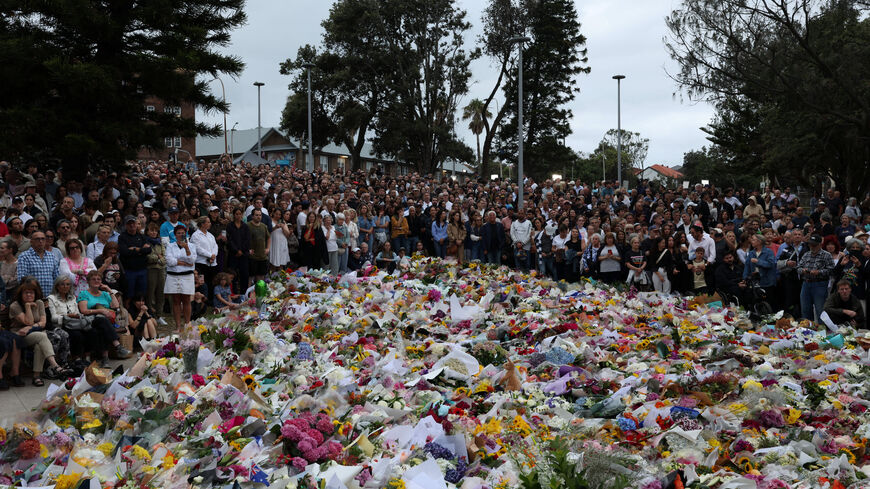 People lay flowers and pay tributes at Bondi Beach to honour the victims of a mass shooting that targeted a Jewish Holiday celebration on Sunday at Bondi Beach, in Sydney, Australia, December 16, 2025. REUTERS/Hollie Adams
