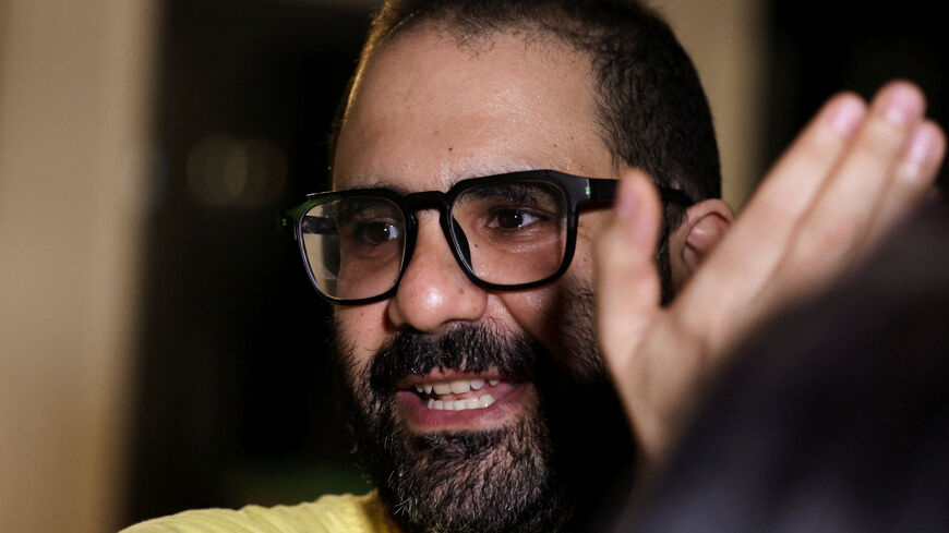 Prominent British-Egyptian activist Alaa Abd el-Fattah, who was released from prison after Egyptian President Abdel Fattah al-Sisi issued a presidential pardon for him, gestures as family and friends gather at home in Giza, Egypt, September 23, 2025. REUTERS/Mohamed Abd El Ghany