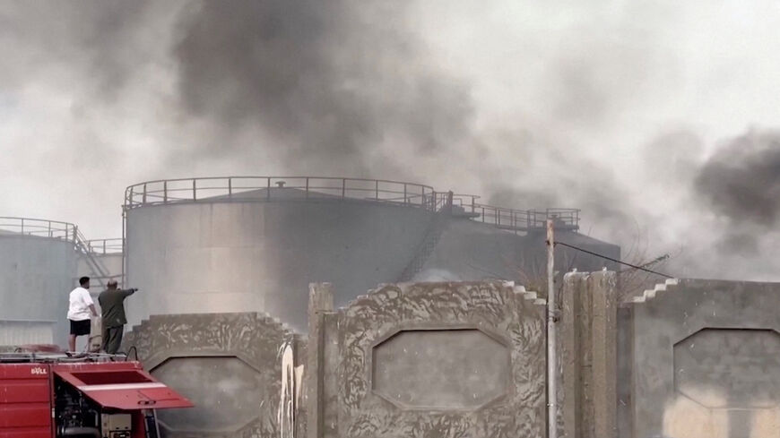 A person gestures towards smoke rising in the aftermath of a Saudi-led coalition airstrike, which targeted what it described as foreign military support to UAE-backed southern separatists, in Yemen's southern port of Mukalla, in this screengrab from a handout video obtained by Reuters on December 30, 2025. Aden al-Mustakillah TV/Handout via REUTERS