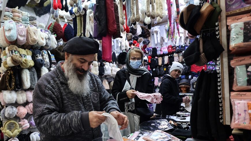 A shopkeeper tidies his stall in Tajrish Bazaar in the Iranian capital. Some traders have protested the rising price of imports as the rial falls against the dollar