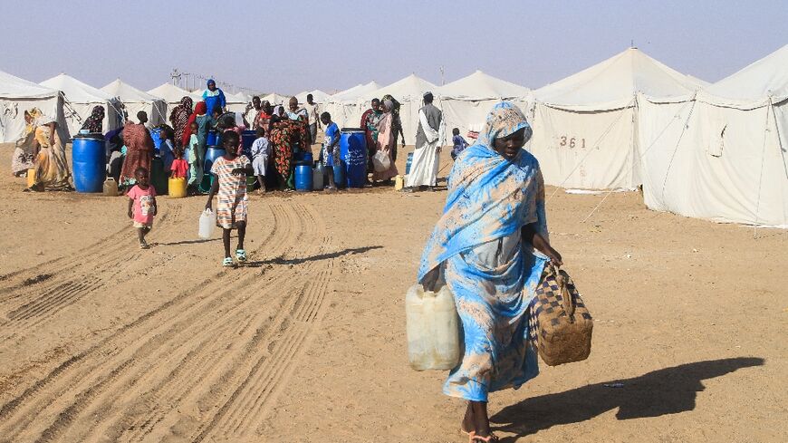 Sudanese who fled massacres and sexual violence in El-Fasher in Darfur carries jerrycans have sought refuge in camps in the north of the country 