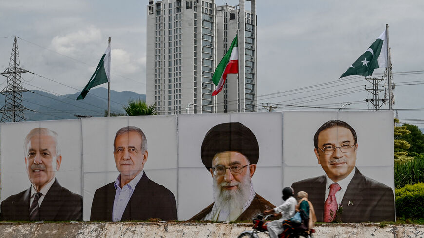 A motorcyclist rides past a banner with the portraits of (L-R) Pakistan's Prime Minister Shehbaz Sharif, Iran's President Masoud Pezeshkian, Iran's Supreme Leader Ayatollah Ali Khamenei and Pakistan's President Asif Ali Zardari, welcoming Iran's president during his state visit in Islamabad on August 2, 2025. (Photo by Farooq NAEEM / AFP) (Photo by FAROOQ NAEEM/AFP via Getty Images)