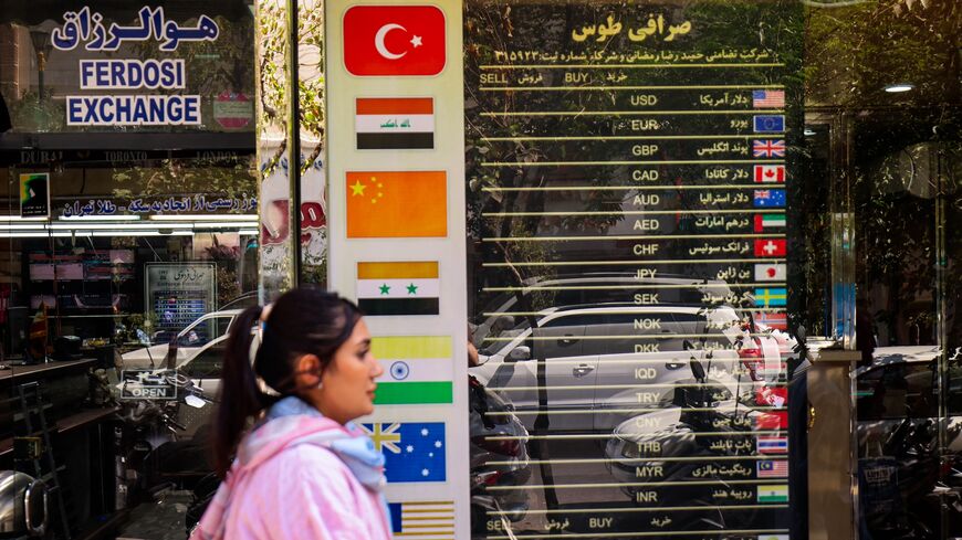 A woman walks past a currency exchange office in Tehran on Sept. 28, 2025, as Iranians feel economic strain deepen, with prices soaring and the rial sinking to new lows. 