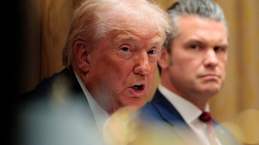 US Secretary of War Pete Hegseth (R) looks on as U.S. President Donald Trump speaks during a meeting of his Cabinet in the Cabinet Room of the White House on December 02, 2025 in Washington, DC. (Chip Somodevilla/Getty Images)