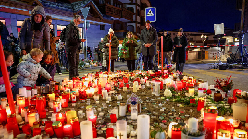 People gather by a makeshift memorial near the "Le Constellation" bar, after a fire and explosion during a New Year's Eve party in which people died and others were injured, in the upscale ski resort of Crans-Montana in southwestern Switzerland, January 2, 2026. REUTERS/Denis Balibouse