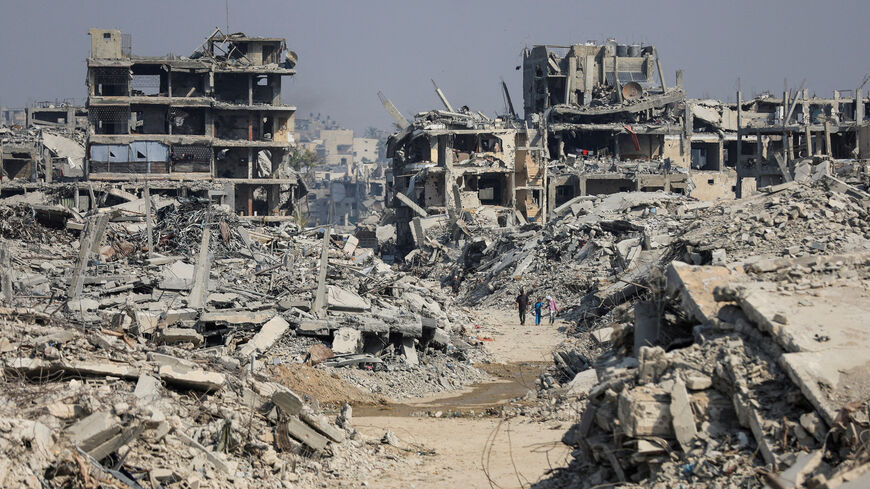 FILE PHOTO: Palestinians walk past destroyed buildings following Israeli military operations in Gaza City, November 7, 2025. REUTERS/Dawoud Abu Alkas/File Photo