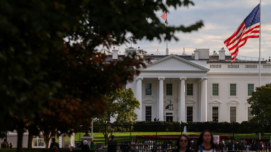 A U.S. flag flies in front of the White House as people walk by, weeks into the continuing U.S. government shutdown, in Washington, D.C., U.S., October 24, 2025. REUTERS/Kylie Cooper