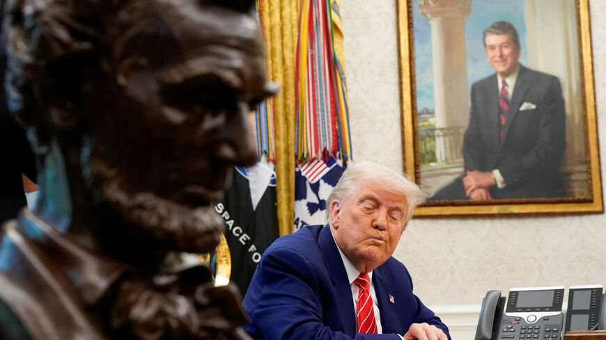U.S. President Donald Trump reacts next to a portrait of former U.S. President Ronald Reagan during a press conference with Elon Musk (not pictured) in the Oval Office of the White House, in Washington, D.C., U.S., May 30, 2025. REUTERS/Nathan Howard