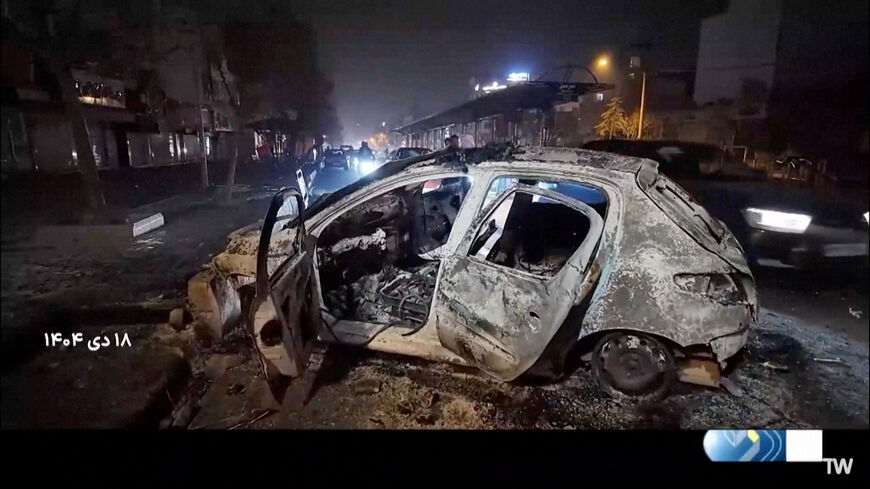 A burnt car lies on the road following unrest sparked by dire economic conditions, in a place given as Tehran, Iran, January 10, 2026, in this screengrab from Iran's state media broadcast footage. IRIB via WANA(West Asia News Agency) via REUTERS