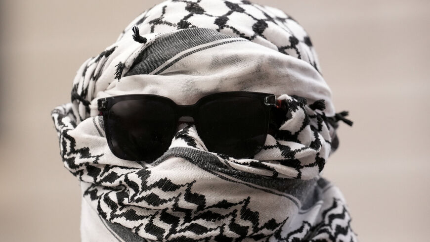 A person with a keffiyeh wrapped around their head takes part in a protest outside London's Old Bailey as four pro-Palestinian activists have pleaded not guilty to breaking into a British military air base and damaging two planes in protest against Britain's support for Israel, in London, Britain, January 16, 2026. REUTERS/Maja Smiejkowska