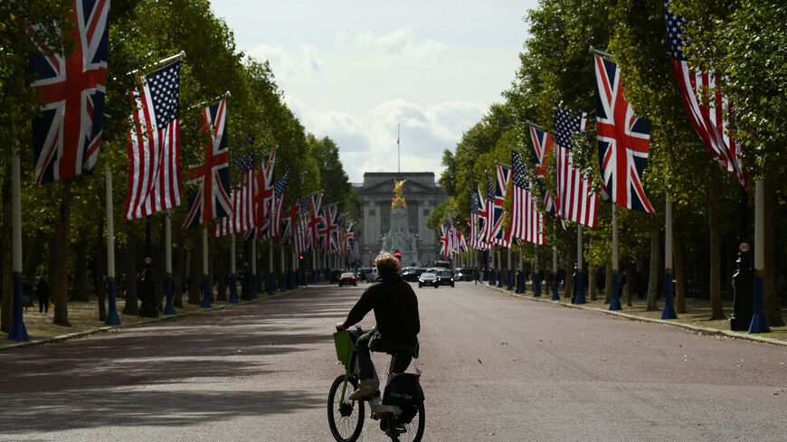 FILE PHOTO: A man rides an e-bike across the road as U.S. flags and British flags line The Mall in front of Buckingham Palace ahead of U.S. President Donald Trump and first lady Melania Trump's state visit to the UK, in London, Britain, September 16, 2025. REUTERS/Jaimi Joy/File Photo