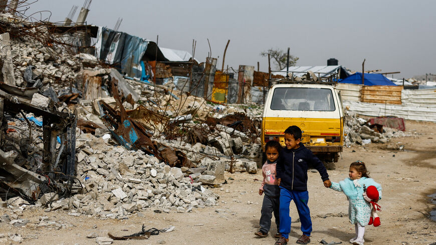 Palestinian children walk past the rubble of residential buildings destroyed during the war, in Gaza City, January 28, 2026. REUTERS/Mahmoud Issa